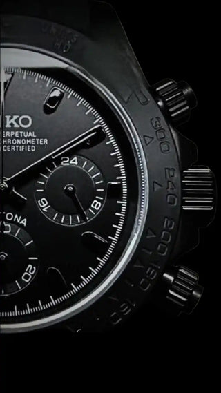 Black chronograph watch face with multiple subdials and markers.