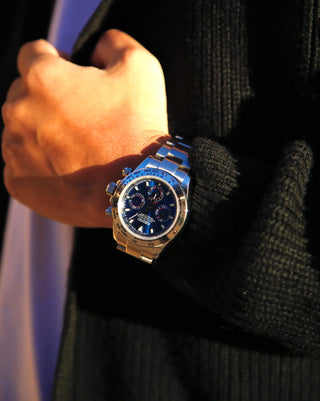 Blue-faced stainless steel wristwatch with metallic bracelet.