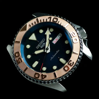 Seiko dive watch with a rose gold bezel and dark blue dial.