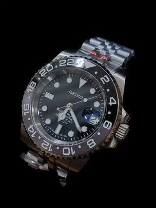 Stainless steel Seiko GMT watch with a black dial and rotating bezel.